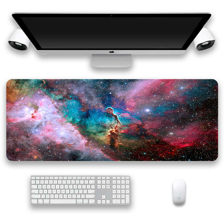 Computer setup with a desk mat featuring a colorful nebula design, keyboard, and mouse.