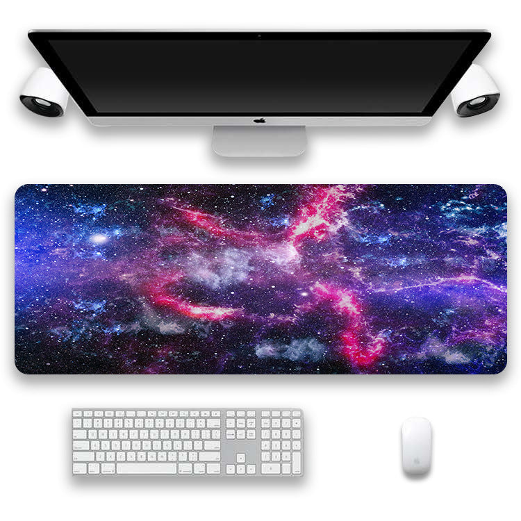 Space-themed desk mat with a computer setup including a monitor, keyboard, and mouse.