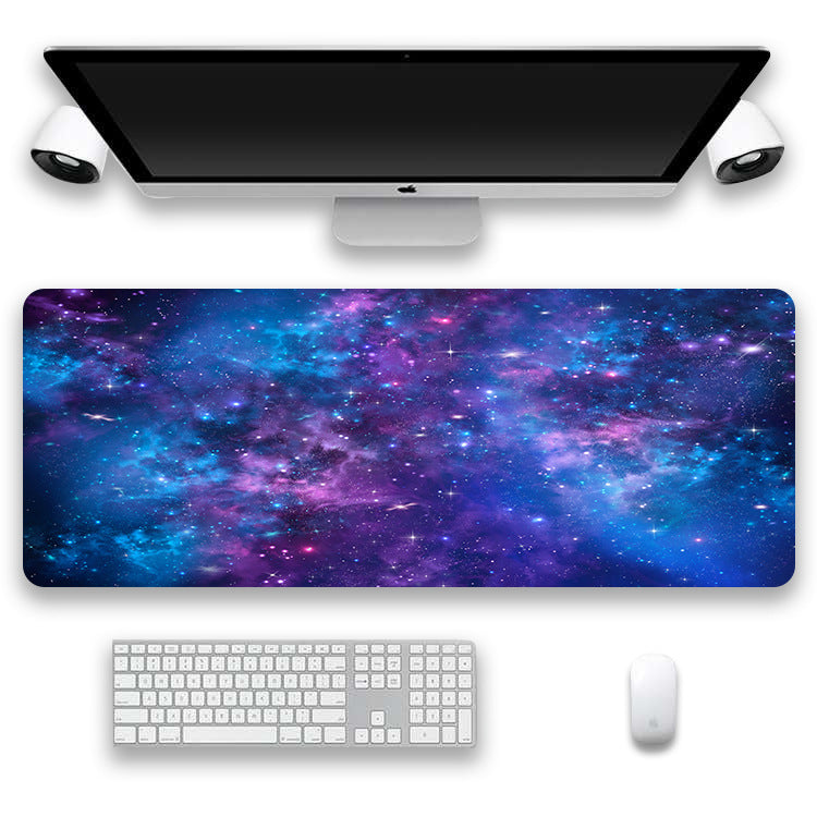 Desk setup with a galaxy-themed mouse pad, keyboard, and monitor on a white background