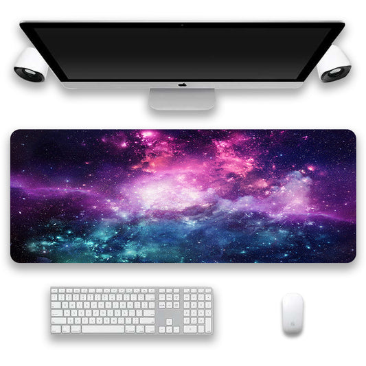 Desk setup with a galaxy-themed mouse pad, keyboard, and monitor on a white background