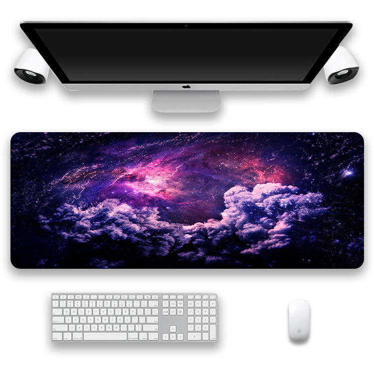Computer setup with a large desk mat featuring a cosmic design, keyboard, and mouse.