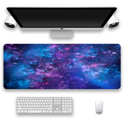 Desk setup with a galaxy-themed mouse pad, keyboard, and monitor on a white background